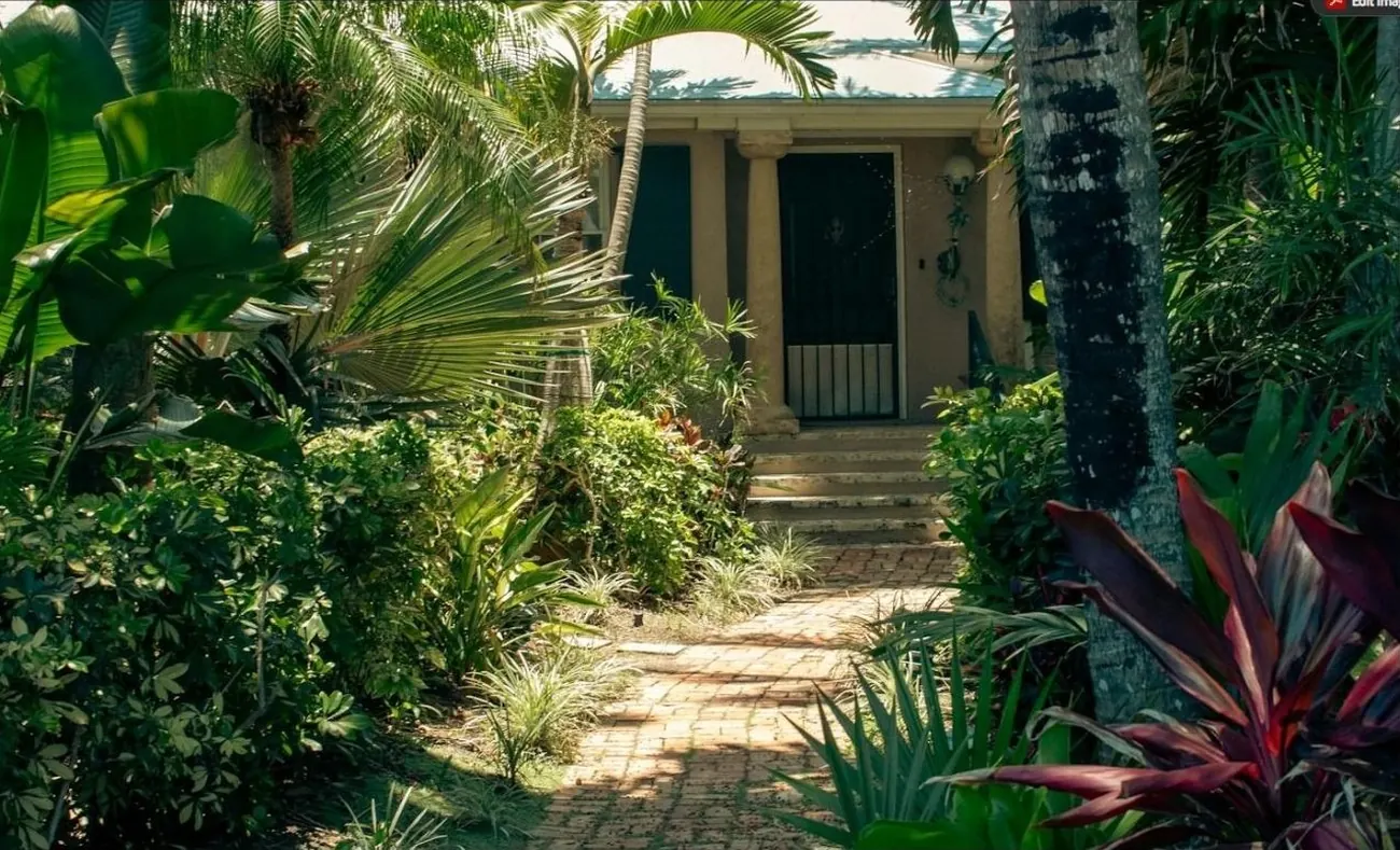 Lush tropical garden path leading to a Pinecrest-style home