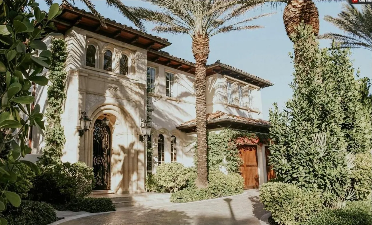 Mediterranean-style estate home with barrel-tile roof and palm trees